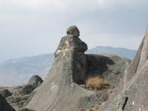 This enormous rock (which actually resembles a ship) located in the south zone of the plateau, near the Fortress and the Cachu Cachu lagoon (Table 1) gets its name from the fact that three lines of sight appear to converge on it: that of the man  in Figures 13a and 13b, from a woman on the opposite side (Figure 13c) – the rock with the man and woman barely visible from the front (the “keel”) are shown in Figure 13d – and the head of a dog on the left is given in Figure 13e. The photos were taken in August 2003.