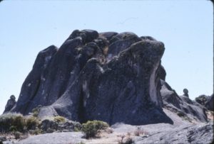 This enormous rock (which actually resembles a ship) located in the south zone of the plateau, near the Fortress and the Cachu Cachu lagoon (Table 1) gets its name from the fact that three lines of sight appear to converge on it: that of the man  in Figures 13a and 13b, from a woman on the opposite side (Figure 13c) – the rock with the man and woman barely visible from the front (the “keel”) are shown in Figure 13d – and the head of a dog on the left is given in Figure 13e. The photos were taken in August 2003.
